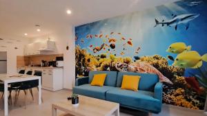 uma sala de estar com um sofá azul e um mural de peixe em L'Aquarium em Boulogne-sur-Mer