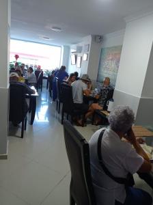 un grupo de personas sentadas en mesas en un restaurante en Karin Hotel, en Ríohacha