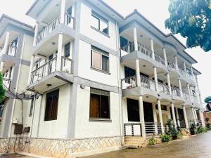 a white apartment building with balconies on a street at Casa Mia BnB in Kampala