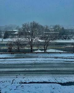 a snow covered road with trees and a fence at 2BR-Free parking, Near Gillette & Providence-I-95 in Pawtucket