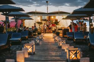 a wooden walkway with chairs and people on the beach at Athina Villa in Zilotí +38 photos