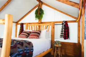 una camera con letto in legno e cuscini di Sundance By Basecamp a Kananaskis Village