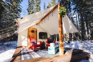 ein Zelt mit einem Tisch und Stühlen im Schnee in der Unterkunft Sundance By Basecamp in Kananaskis Village