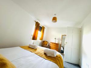 een slaapkamer met een bed met twee handdoeken erop bij Tillicoultry Jupiter Apartment - Scotland Holiday Let in Tillicoultry
