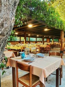 a table and chairs in a restaurant under a tree at Agriturismo Lu Branu in Arzachena