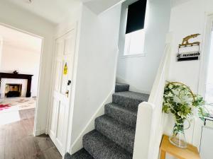 una escalera en una casa con una alfombra gris en Tillicoultry Jupiter Apartment - Scotland Holiday Let en Tillicoultry