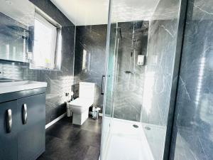 a bathroom with a shower and a toilet and a sink at Tillicoultry Jupiter Apartment - Scotland Holiday Let in Tillicoultry +21 photos