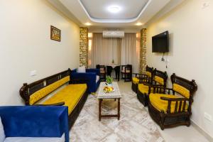 una camera con divani, tavolo e TV di Diamond Pyramids View Inn a Il Cairo