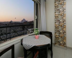 un tavolo con una pianta in vaso sul balcone di Diamond Pyramids View Inn a Il Cairo