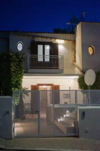 a house with a gate in front of it with a clock at Anemos Suites Macari - San Vito Lo Capo in Macari
