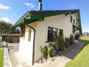 una pequeña casa blanca con techo verde en Haus im Rietle en Schaan