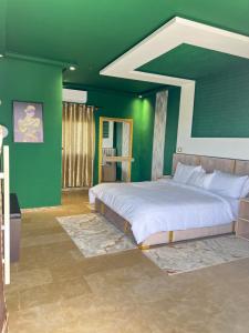 a bedroom with a large bed with green walls at Auberge Billionaire in Fès