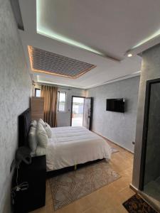 um quarto com uma cama grande e uma televisão em Auberge Billionaire em Fez