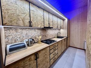 a kitchen with wooden cabinets and a counter top at Milenium magic villa on Sevan beach in Sevan