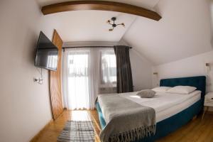 1 dormitorio con 1 cama, TV y ventana en Vama Chalet, en Molidu