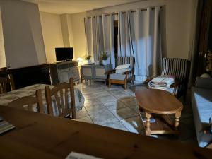 sala de estar con sofá, mesa y sillas en La Fusteria del Casat, en Sarroca de Bellera