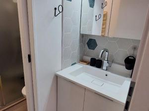 a white bathroom with a sink and a mirror at Studio Courchevel, 1 pièce, 2 personnes - FR-1-514-80 in Courchevel