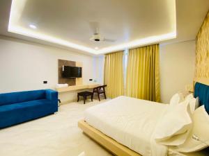 a bedroom with a bed and a blue couch at Hotel Holiday Grand in Greater Noida