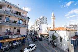 una calle de la ciudad con edificios y una mezquita en THEMIS URBAN STAY, en Komotiní