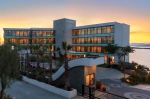 a large building with a sunset in the background at Le Meridien Bodrum Beach Resort in Bogazici