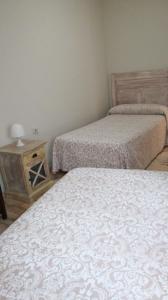 a room with two beds and a night stand with two beds at Gran piso familiar in Córdoba