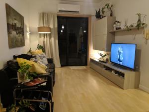 een woonkamer met een bank en een flatscreen-tv bij Gaia St Paul's Bay Modern Cosy Apartment in St Paul's Bay