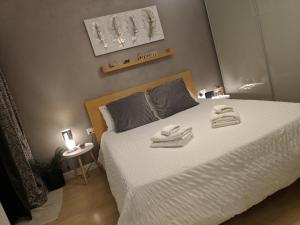 een slaapkamer met een bed met twee handdoeken erop bij Gaia St Paul's Bay Modern Cosy Apartment in St Paul's Bay