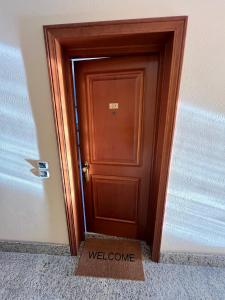 a wooden door with a welcome sign in front of it at IL PARCO 2 in Rome