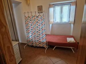 a bathroom with a red bench and a window at Casa Alentejana in São Teotónio