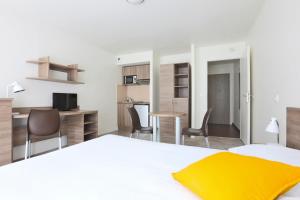 Schlafzimmer mit einem Bett, einem Schreibtisch und Stühlen in der Unterkunft Kosy Appart'hôtels Art'&Facts in Nancy