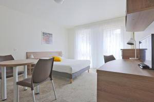 a hotel room with a bed and a table and chairs at Kosy Appart'hôtels Art'&Facts in Nancy +13 photos