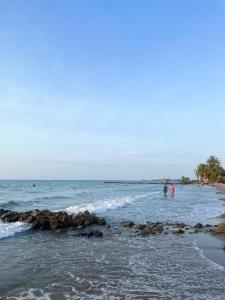 duas pessoas de pé na água na praia em Manglearena em Tolú