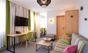 a hotel room with a couch and a desk at Hotel Boehler in Böblingen