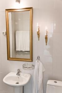 a bathroom with a sink and a mirror and a toilet at Officersvillorna, Älvkarleby Vandrarhem in Älvkarleby