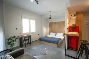 コモティニにあるTHEMIS URBAN STAYの部屋にベッドと机がある寝室