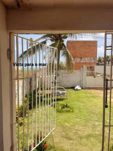 Casa de praia em Muriú في Ceará-Mirim: قفص مع نخلة في ساحة