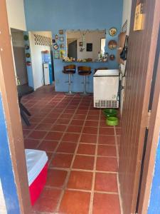 un bagno con pavimento piastrellato rosso e una cucina di Casa de praia em Muriú a Ceará-Mirim