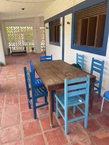 uma mesa de madeira e cadeiras azuis num pátio em Casa de praia em Muriú em Ceará-Mirim
