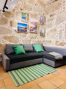 - un canapé dans une chambre dotée d'un mur en pierre dans l'établissement Quinta Lourenca - Vila do Conde, à Vilar