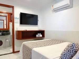 a bedroom with a bed and a flat screen tv at Vila Jeri Hotel in Jericoacoara