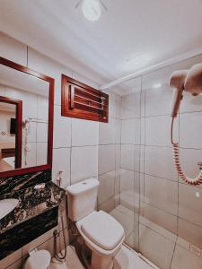 a bathroom with a toilet and a shower and a sink at Vila Jeri Hotel in Jericoacoara