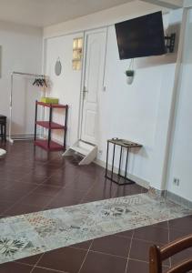 uma sala de estar com televisão e piso em azulejo em Escale chez Joëlle & Alain em Le Lamentin