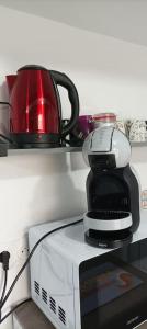 eine Kaffeemaschine auf einer Mikrowelle in der Unterkunft studio 20 min aéroport CDG in Othis