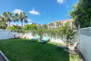 a yard with chairs and a fence with a fountain at Closest Studio Suite to Vanderbilt Beach, new remodel, well appointed, BBQ, yard, very private plus many extras! in Naples