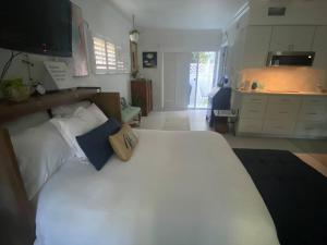 a bedroom with a large white bed with blue pillows at Closest Studio Suite to Vanderbilt Beach, new remodel, well appointed, BBQ, yard, very private plus many extras! in Naples