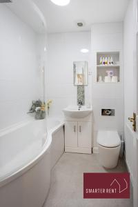 ein weißes Bad mit einem WC und einem Waschbecken in der Unterkunft Woking, Knaphill - 2 Bed House - Parking & Garden in Brookwood