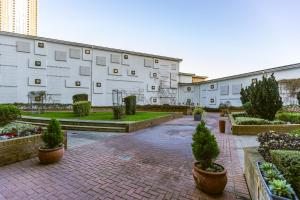 a building with a courtyard with trees and plants at Corporate Canary Suite in London