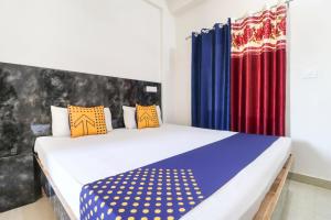 Sohāna的住宿－OYO Spring Woods Suites，一间卧室配有一张带色彩缤纷枕头的大床