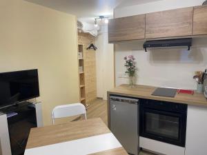 Chalet Lou Via location في أبودونس: مطبخ صغير مع طاولة وقمة كونتر