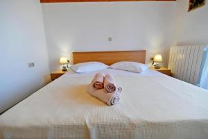um quarto com uma cama com uma toalha em Apartments for families with children Opatija - Pobri, Opatija - 7890 em Matulji